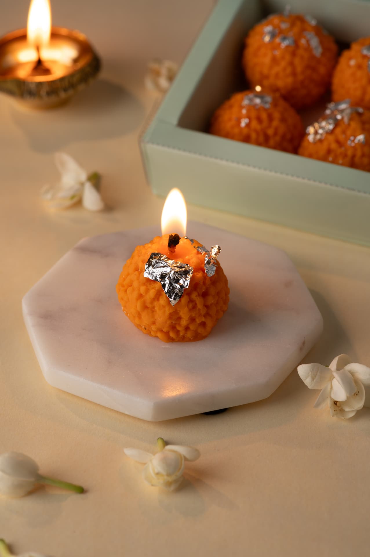 Lit motichoor laddoo candle with silver vark from the Riwayat Diwali collection